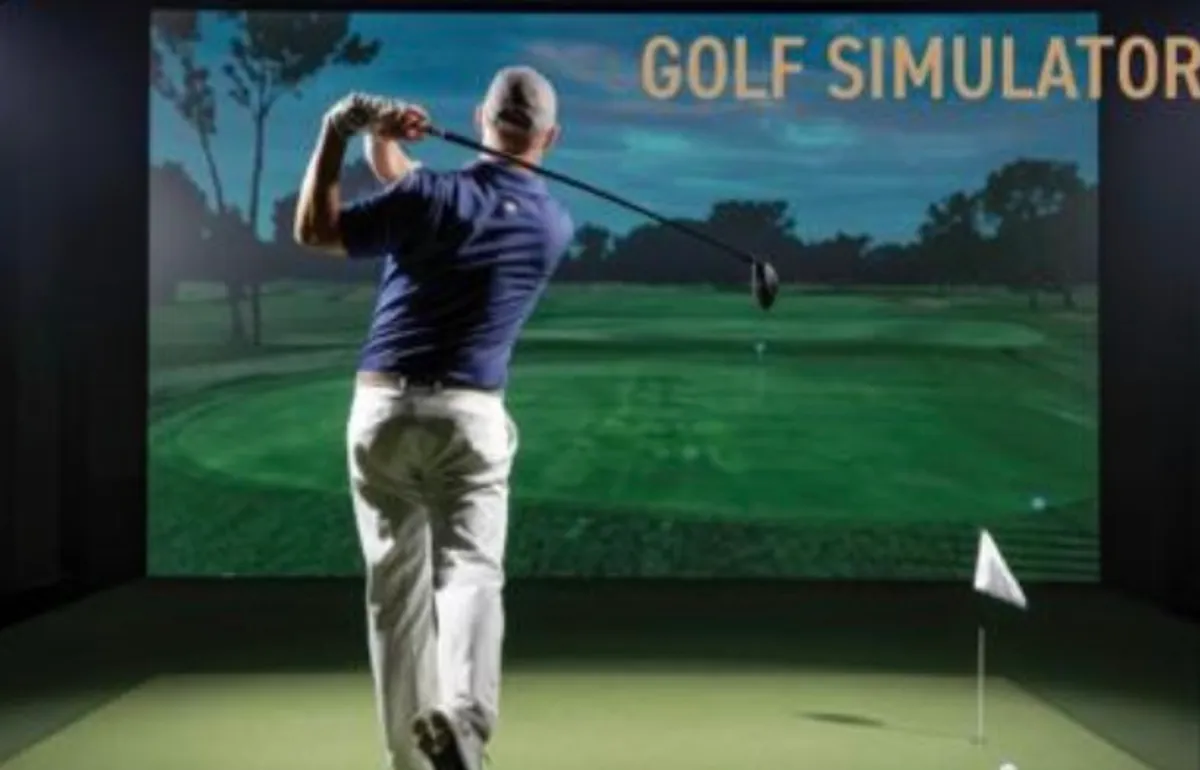 Golfer swinging in front of a full-size golf simulator impact screen lit by the Aureon AZ8600 short-throw projector