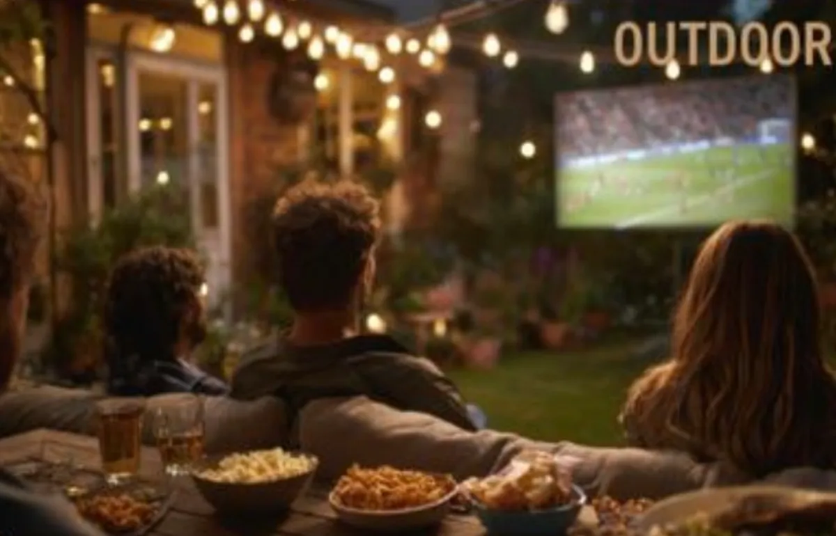Backyard movie night with a football match projected on an outdoor screen by the Aureon AZ8600 projector